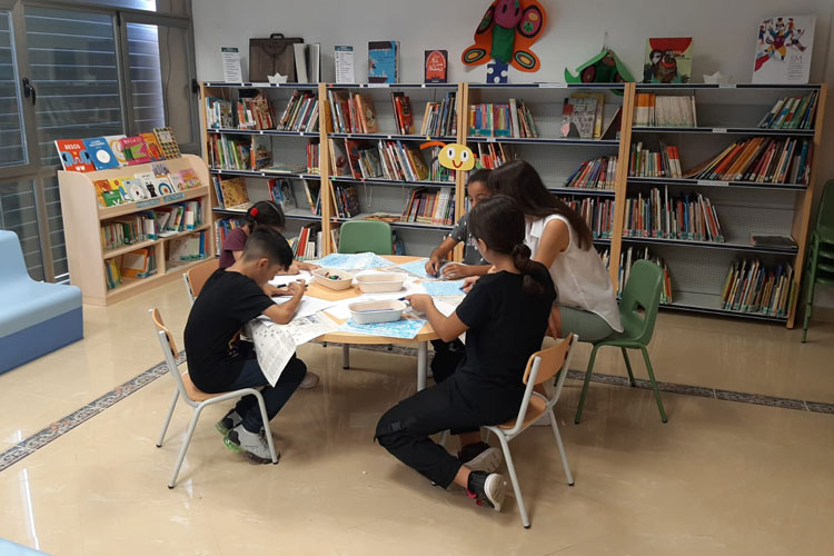 Niños y niñas en la biblioteca de Gelsa