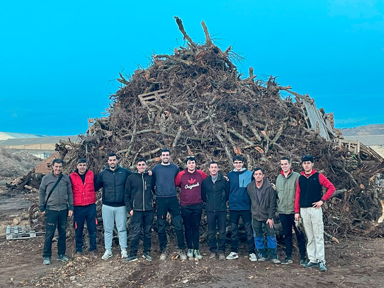 Equipo de voluntarios con la hoguera que ardió en la noche de San Antón